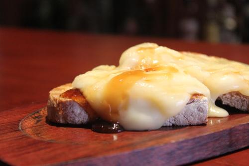 a piece of bread with cheese on top on a plate at Hotel Eurosol Seia Camelo in Seia