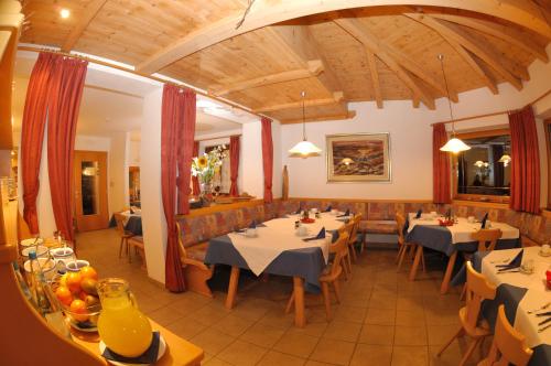 a restaurant with tables and chairs in a room at Residence Viktoria in Castelrotto