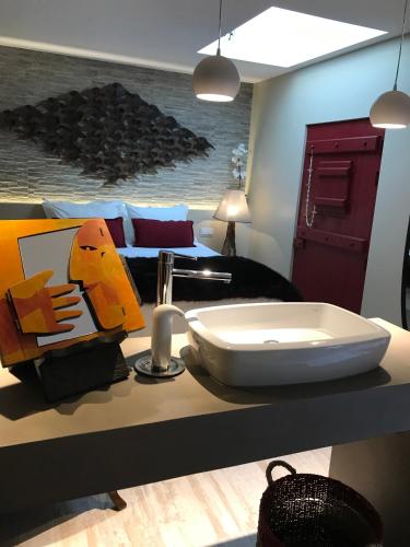 a bathroom with a sink on a counter with a bed at Casa do Sobro in Santo Estêvão