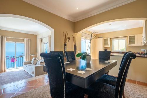 a dining room with a table and chairs at Designed Villa Palheiro Village by Holiday Rental Madeira in Funchal
