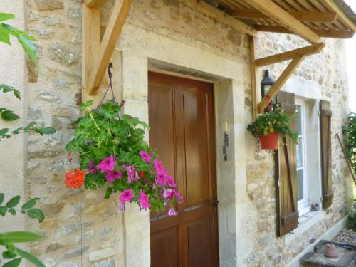 a door to a stone house with flowers on it at La roulotte de Pommette et Billy - Larès in La Hoguette