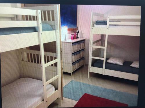 a room with three bunk beds and a desk at Jesolo pineta oasi verde ,spiaggia e mare in Lido di Jesolo