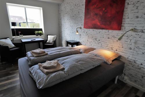 - 2 lits dans une chambre avec un mur en briques dans l'établissement A-Bed, à Esbjerg