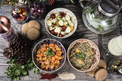 a table topped with bowls of food and other foods at Dar Mayshad Riad - Luxurious Boutique Hotel in the Medina in Rabat