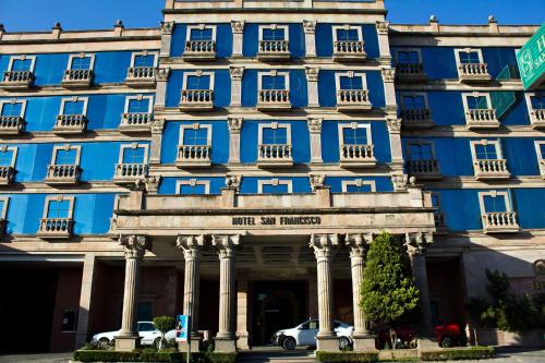 a blue building with a car parked in front at Hotel San Francisco Leon in León