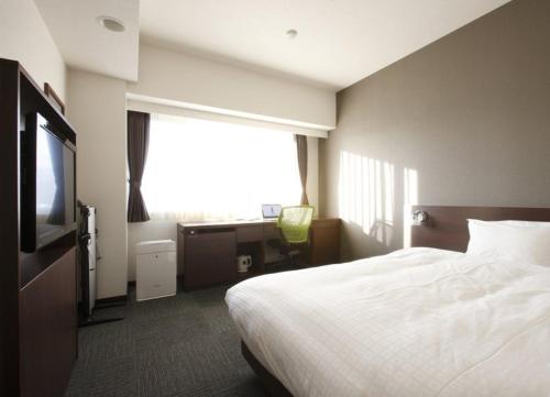 Habitación de hotel con cama y TV en Hotel Just One Susono, en Susono