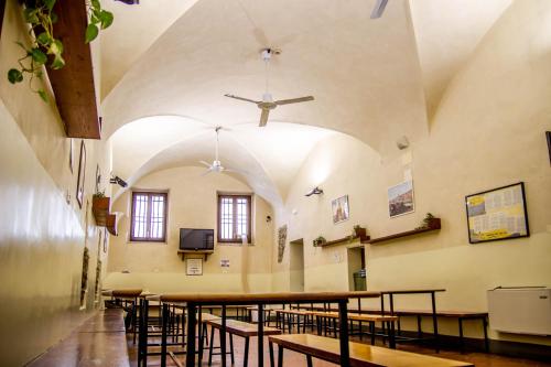 a room with tables and chairs and a ceiling at Hostel Santa Monaca in Florence