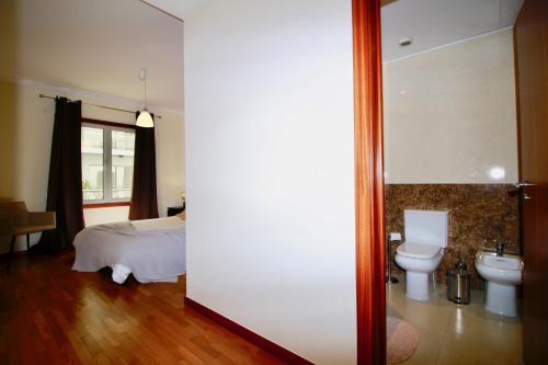 um quarto com uma cama, um WC e um lavatório em Madeira Emotions Apartments by AnaLodges em Funchal