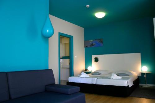 - une chambre avec un lit et un mur bleu dans l'établissement Apartments Villa Azzurra Bol, à Bol