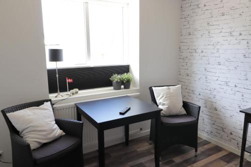 a dining room with a table and two chairs and a window at A-Bed in Esbjerg