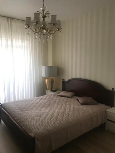 een slaapkamer met een groot bed en een kroonluchter bij Апартаменти in Mizhhirya