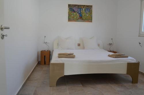um quarto com uma cama branca e toalhas em Casa Blanca em Chiclana de la Frontera