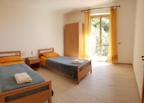 een slaapkamer met twee bedden en een groot raam bij Marea Retreat Apartments in Marina di Camerota