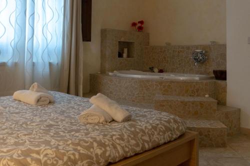 ein Schlafzimmer mit einer Badewanne und einem Bett mit Handtüchern in der Unterkunft Guarda Che Luna in Sasso di Castalda
