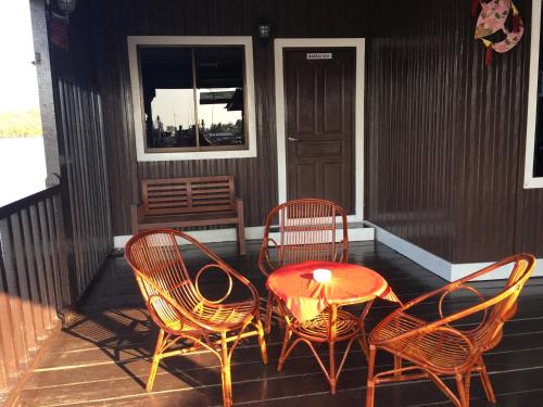 a table and four chairs on a porch at Maena Water Chalets in Tumpat