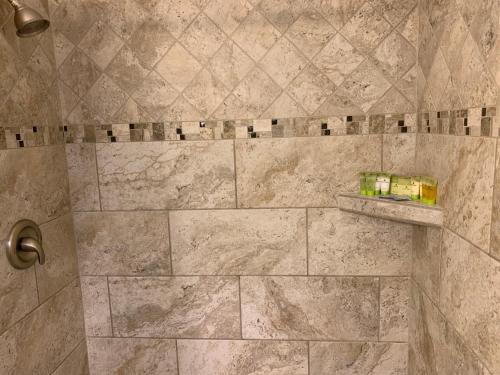 y baño con ducha y azulejos de mármol. en Twin Palms at Siesta, en Siesta Key