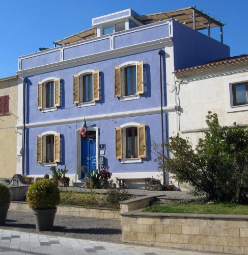 a blue house with yellow shutters on a building at Brancadoria B&B in Monteleone Rocca Doria