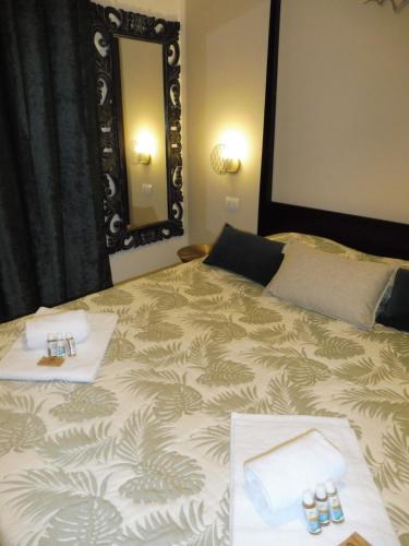 a bedroom with a bed with two towels and a mirror at Rio Groppo Guesthouse in Manarola