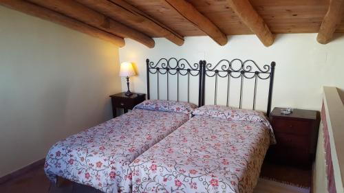 a bedroom with a bed with a red and white comforter at Finca El Manzano in Cortegana