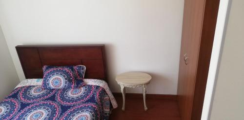 1 dormitorio con cama y mesa pequeña en Habitación con baño privado, en Tunja