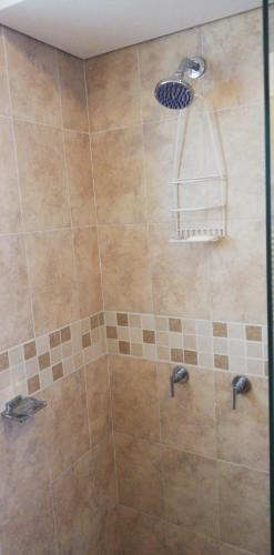um chuveiro com duas torneiras e um chuveiro em Habitación con baño privado em Tunja