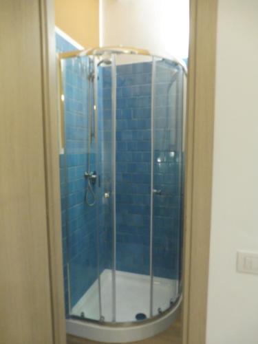 a glass shower with blue tiles in a bathroom at Rio Groppo Guesthouse in Manarola