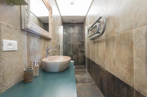 uma casa de banho com uma banheira, um lavatório e um espelho. em Casa Malichi - Rètro Apartment - Centro Storico Perugia em Perugia