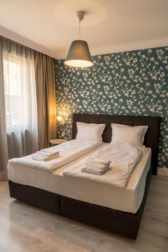 a bedroom with a large bed with a floral wall at Antique Residence in Hisarya