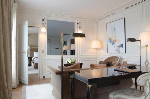 a living room with a desk and two chairs at La Réserve Paris Hotel & Spa in Paris