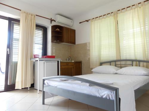 a bedroom with a bed and a small kitchen at Apartmani Villa Jasminka in Podgora