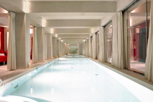 uma piscina no corredor de um edifício em La Réserve Paris Hotel & Spa em Paris