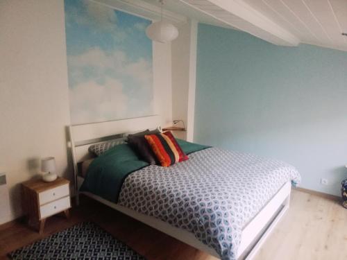 ein Schlafzimmer mit einem Bett und einer blauen Wand in der Unterkunft Duplex Denim in Nîmes
