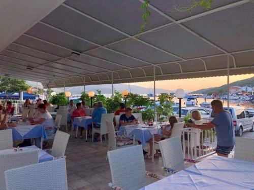 a group of people sitting at tables in a restaurant at Apartment Nadalina in Seget Vranjica