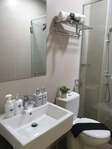 a bathroom with a sink and a toilet and a mirror at ATLANTIS@MELAKA BY SWEETSTAY in Melaka