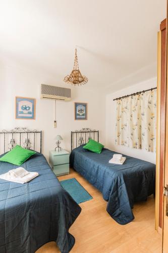 a room with two beds and a chandelier at Quinta Vita - Vila Limao in Almancil