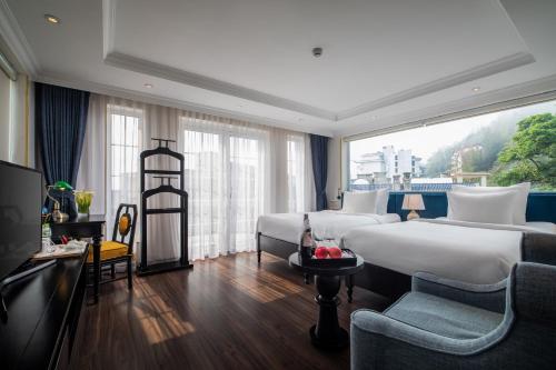 サパにあるMy Boutique Hotel & Spaのベッド2台と大きな窓が備わるホテルルームです。