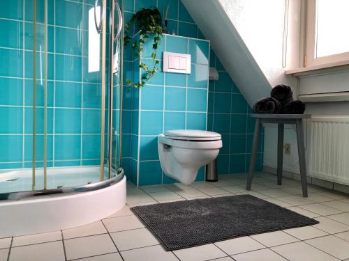 uma casa de banho com WC e uma parede de azulejos azuis em Odyssee em Zandvoort