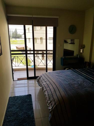 a bedroom with a bed and a view of a balcony at Ria Court 33 in Larnaka