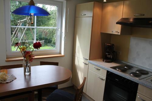 a kitchen with a table with a vase of flowers on it at Ferienwohnung Schmahl in Schleiden