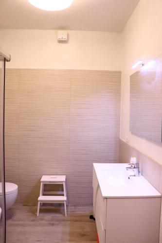 a bathroom with a sink and a toilet and a stool at "Country House il Brolo" in Polpenazze del Garda
