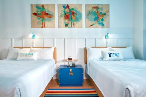two beds sitting next to each other in a room at Universal's Endless Summer Resort - Surfside Inn and Suites in Orlando