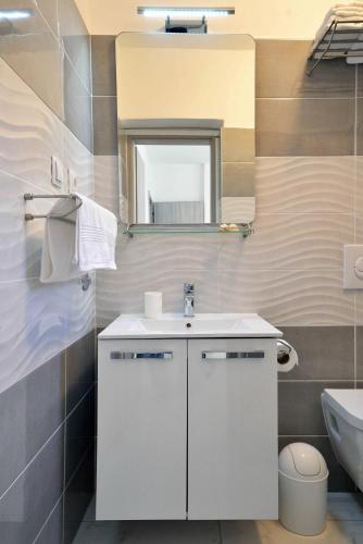 a bathroom with a white sink and a mirror at Apartmani Dora Murter in Murter