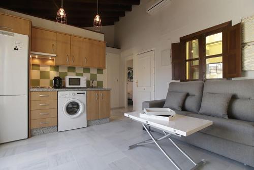 ein Wohnzimmer mit einem Sofa und einer Küche in der Unterkunft ALOJAMIENTO EN SEVILLA-TRIANA in Sevilla