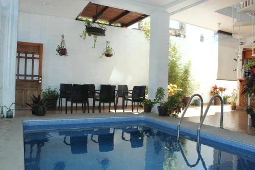 a house with a swimming pool and a table and chairs at LALORA Hotel & Villas in San Patricio Melaque