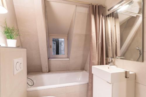 une salle de bain avec une baignoire et un lavabo dans l'établissement CityCosy Strasbourg - Authentique Batelier, à Strasbourg