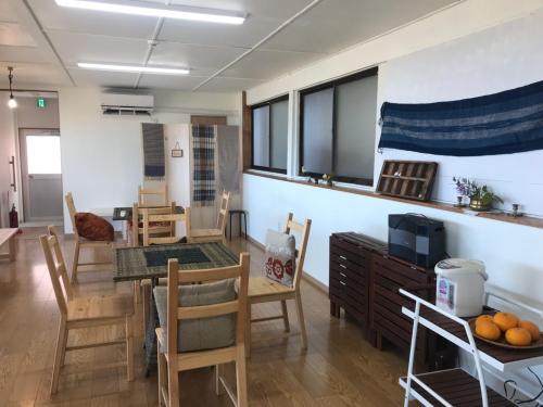 a living room with a table and a dining room at Megijima Island Guesthouse & cafe Megino in Takamatsu