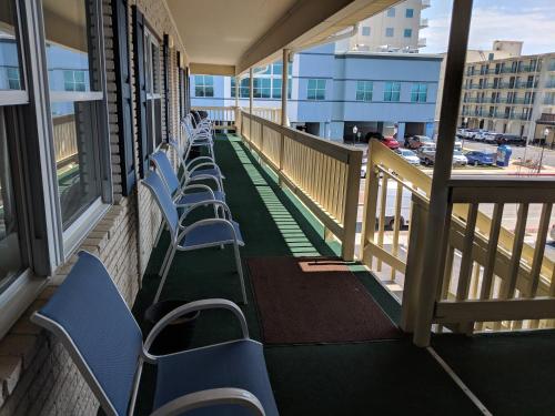 a row of blue chairs on a balcony at Crystal Sands Motel in Ocean City