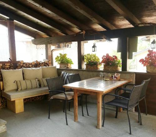 a table and chairs and a bench on a patio at Casa Calvola holiday home in Tenno