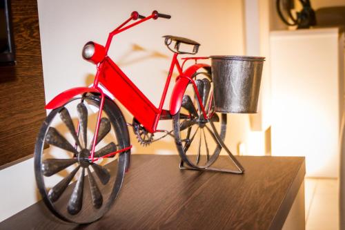 a red bike with a bucket on a table at Lux Apartments in Xgħajra