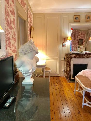 un salon avec une statue sur une table en verre dans l'établissement VILLA la GLORIETTE, à Rouen